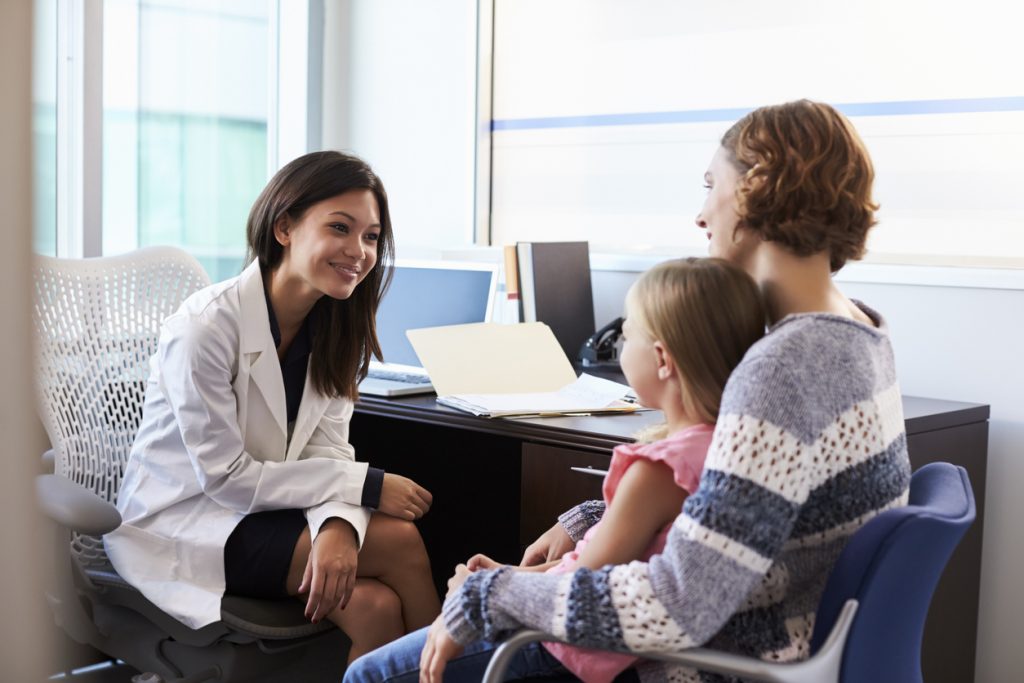 A pediatric clinical researcher meeting with a mother and child